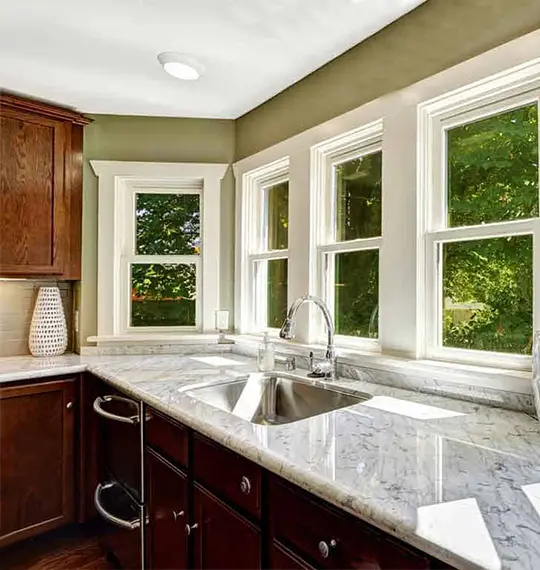 Marble kitchen countertop with trees showing through window